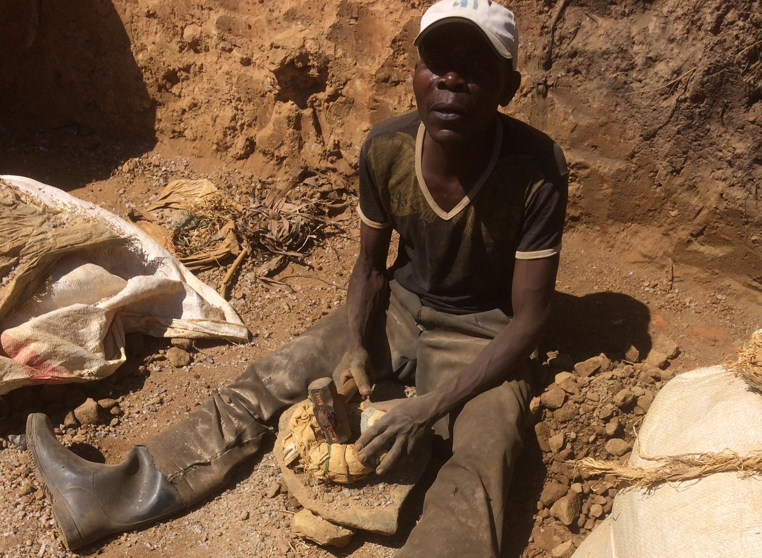 Un artisan utilise un marteau pour concasser des minerais en vue d'éliminer la partie stérile